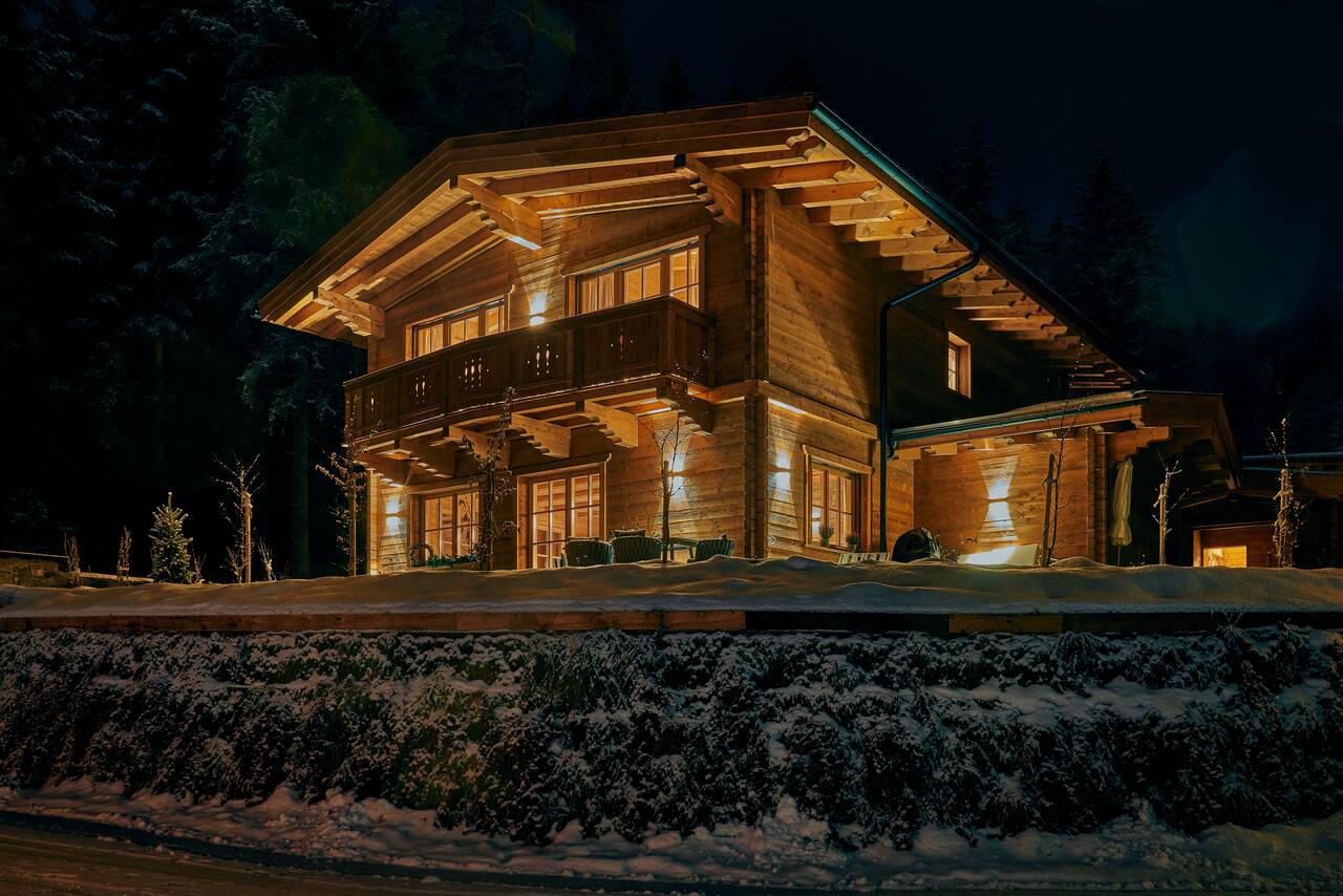 Sissi's Green Chalets bei Nacht — beleuchtetes Holzchalet im Schnee in Leutasch in Seefeld, Tirol
