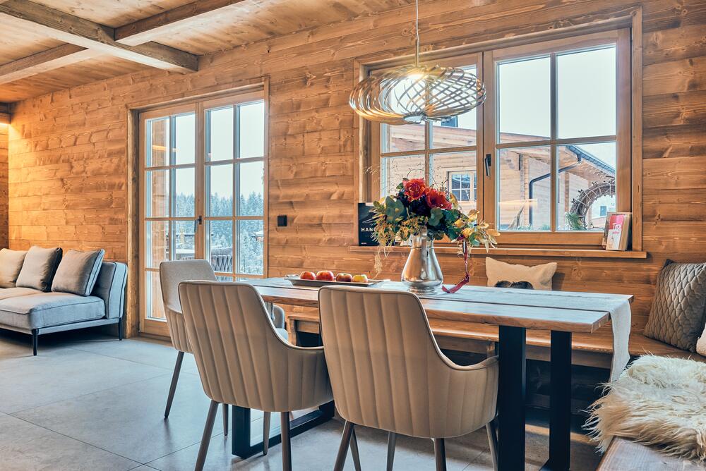 Essbereich mit großem Holztisch und Winterblick im Chalet