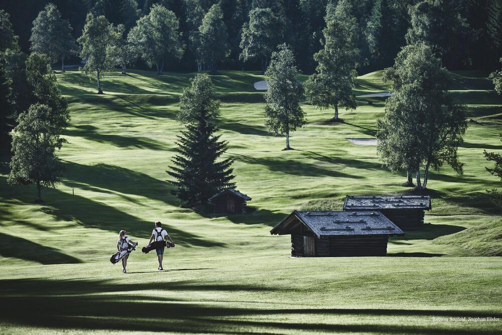 Golfplatz in der Region Seefeld mit alten Almhütten